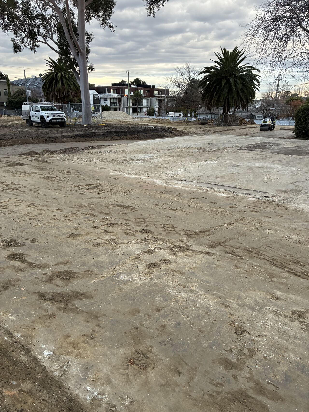 Ground stabilisation works underway on a confined urban site with roller compactor and Arrow Civil ute